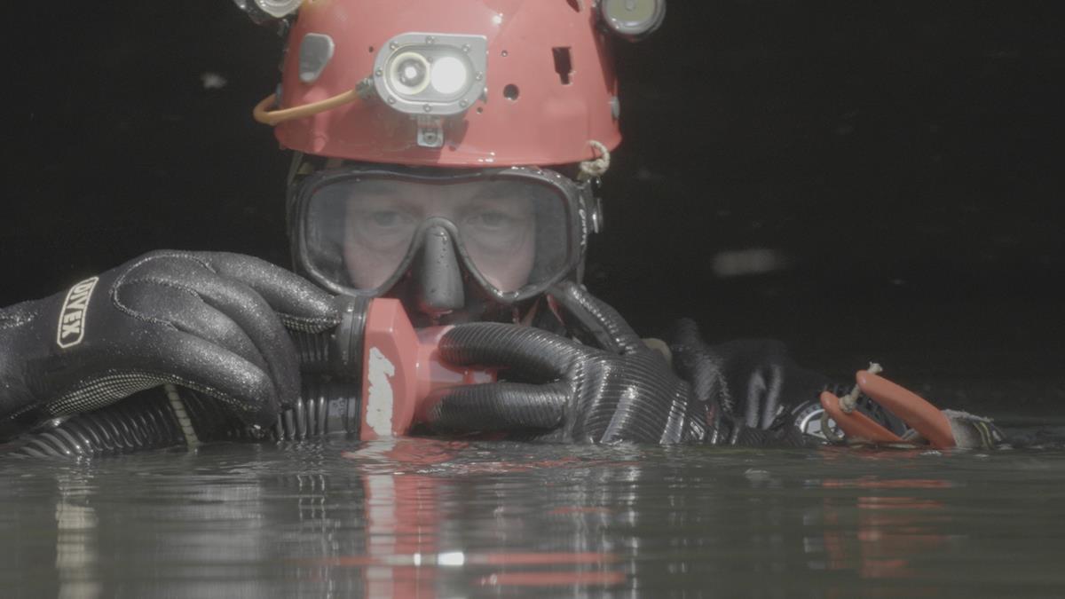 A diver using equipment for breathing while surfaced in a cave in “The Rescue.” Cr: National Geographic