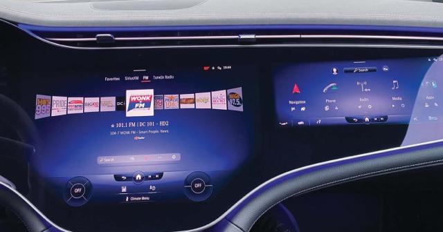 A DTS AutoStage tuning screen is displayed on the MBUX Hyperscreen of a Mercedes EQS electric vehicle. Note the screen in front of the passenger, which here shows a navigation page with a “Radio” icon.